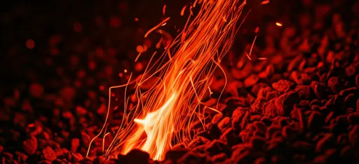 Textured grainy close up of red flames and sparks on dark background